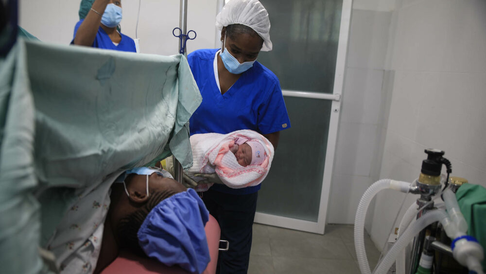 Una enfermera muestra a una madre a su bebé recién nacido después del parto en el Centro Hospitalario Fontaine. (AP Photo/Odelyn Joseph)

