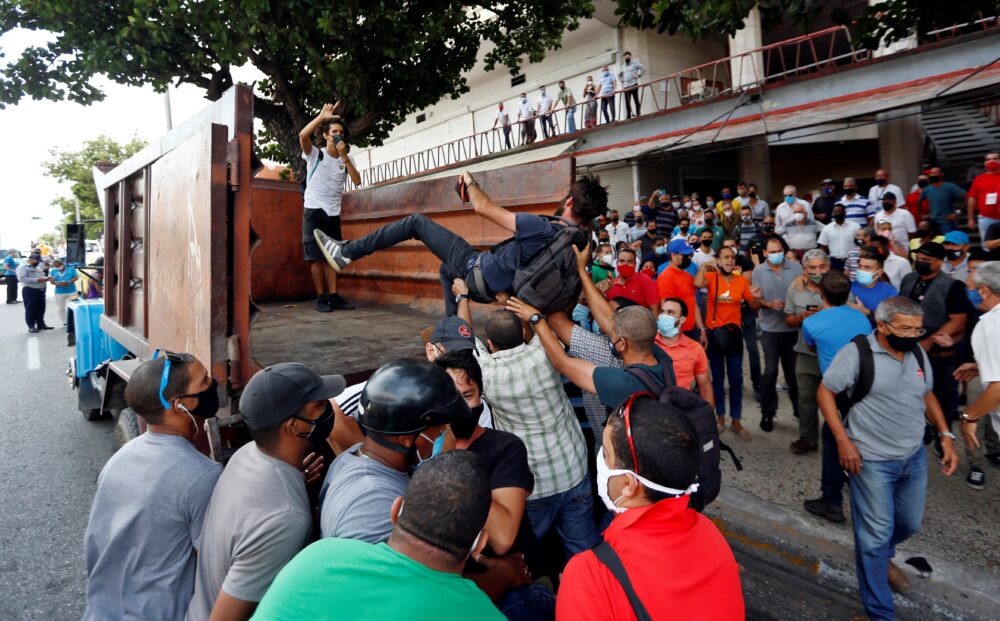 Manifestantes frente al Instituto de Radio y Televisión (ICRT) mientras son montados en un camión en una calle en La Habana (EFE/Ernesto Mastrascusa/Archivo)