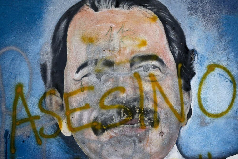 Un mural de Daniel Ortega, con inscripciones en su contra como parte de las protestas contra su régimen y que piden su renuncia en Managua, Nicaragua, el 26 de mayo de 2018 (AP)