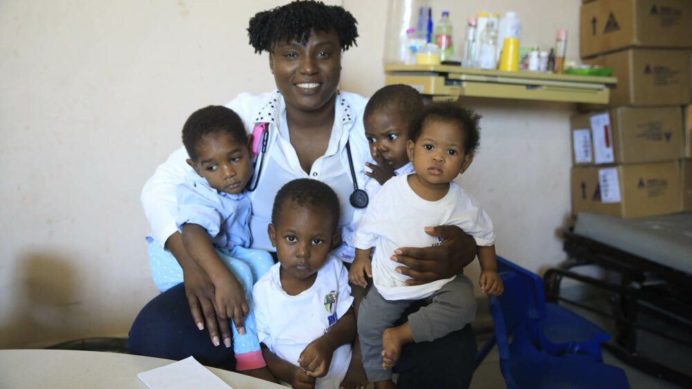 El Dr. Michel Jovania posa para un retrato con pacientes jóvenes en un centro de estabilización de desnutrición. (AP Photo/Odelyn Joseph)

