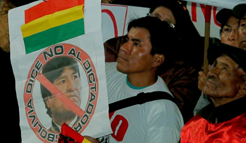 Un manifestante boliviano que se opone a la reelección indefinida sostiene un cártel con la cara de Evo Morales y la leyenda