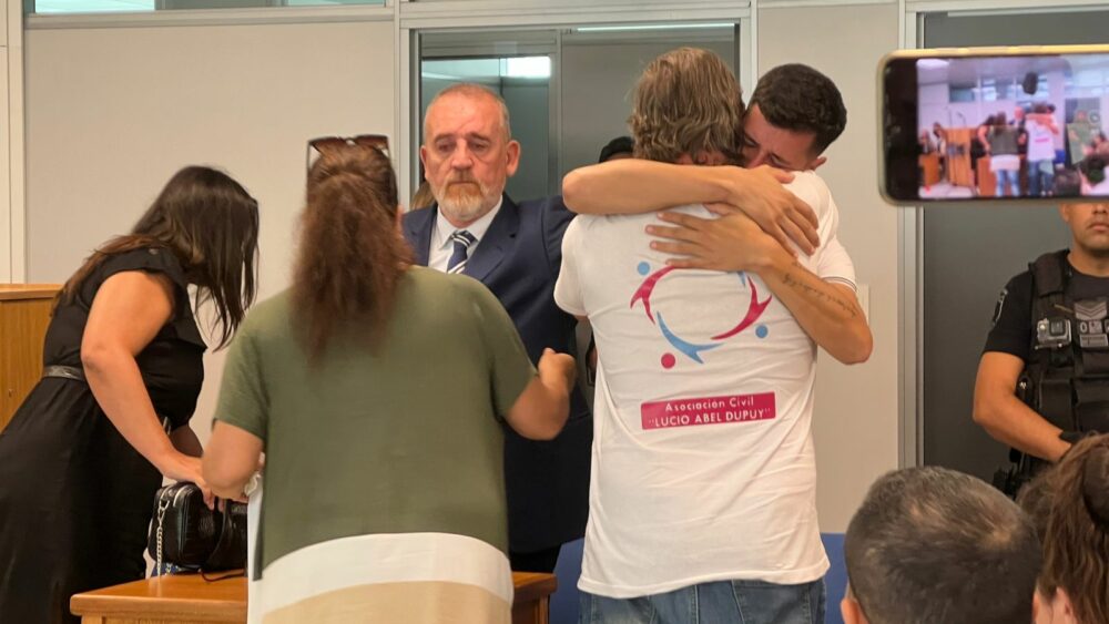 El papa de Lucio y el abuelo, abrazados luego de la lectura del veredicto (Gastón Taylor)