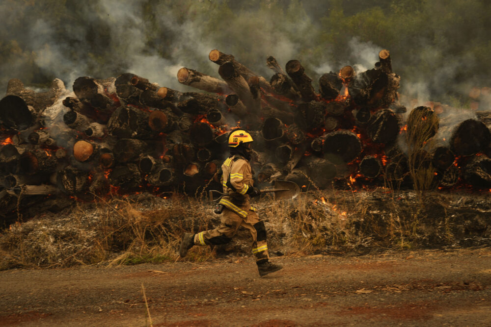 Un bombero corre para combatir las llamas causadas por los incendios forestales en Santa Juana, Chile (Foto AP/Matías Delacroix)