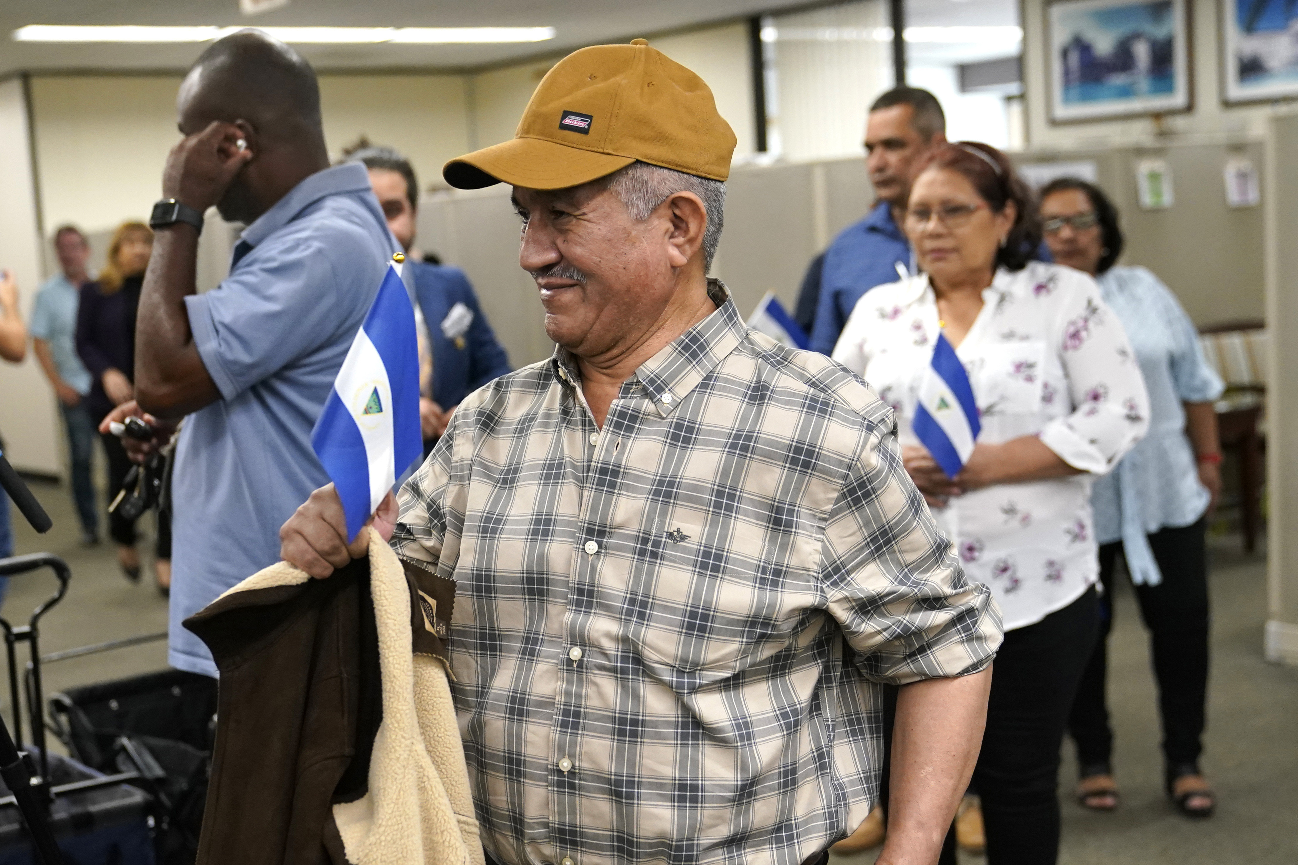 Víctor Manuel Sosa Herrera sostiene una bandera nicaragüense al llegar con otros opositores liberados en Nicaragua para una conferencia de prensa en la oficina de la alcaldesa del condado de Miami-Dade, Daniella Levine-Cava, el miércoles 15 de febrero de 2023 en Miami. El gobierno del presidente Daniel Ortega envió recientemente a Estados Unidos a 222 líderes políticos, sacerdotes, estudiantes, activistas y otros disidentes que estaban presos y cuya liberación fue exigida durante mucho tiempo por la comunidad internacional. (Foto AP/Lynne Sladky)