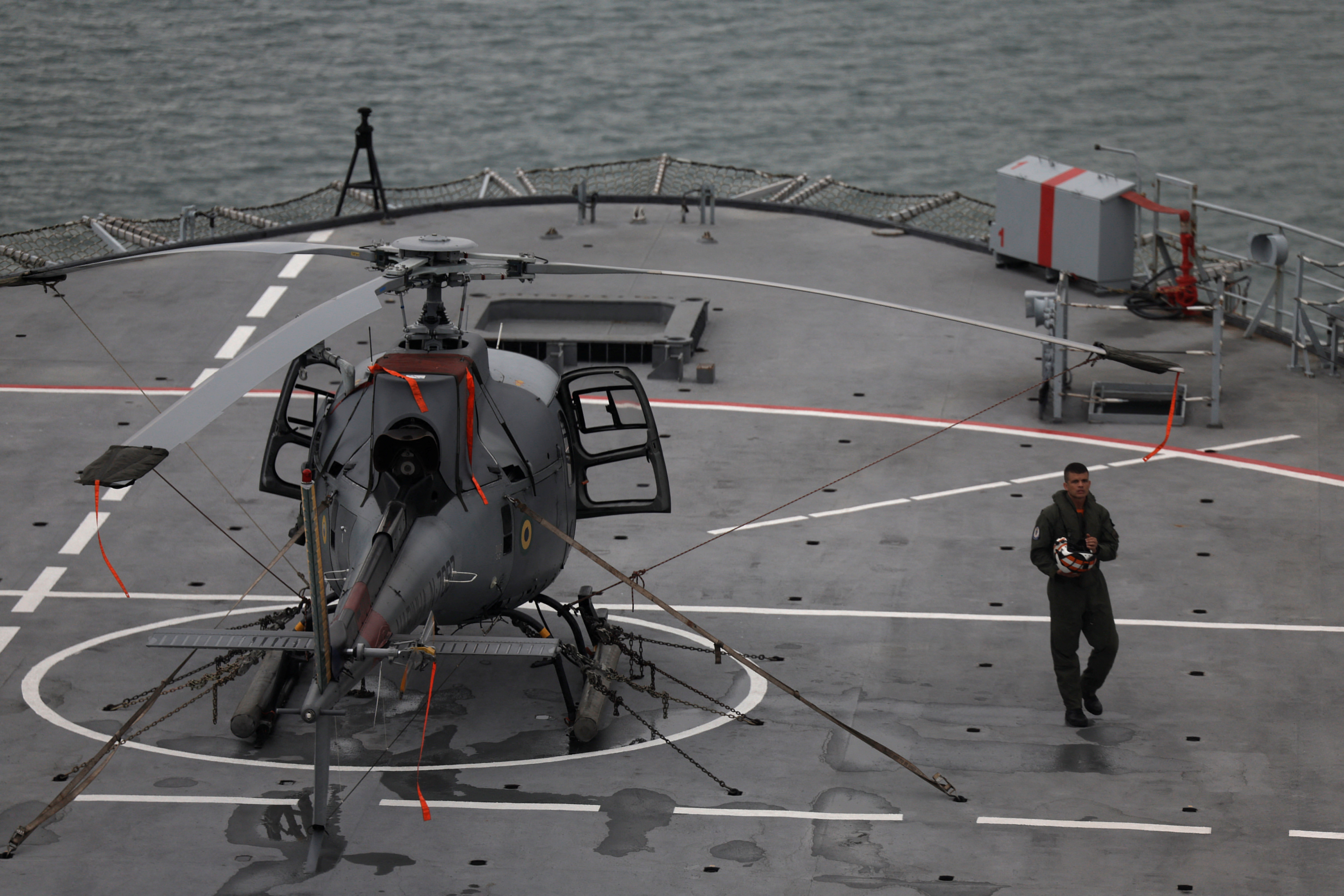 Un miembro de la Marina de Brasil camina junto a un helicóptero a bordo del buque Navio Atlantico durante las operaciones de socorro para las víctimas de los deslizamientos de tierra en Sao Sebastiao, Brasil, el 23 de febrero de 2023 (REUTERS/Roosevelt Cassio)