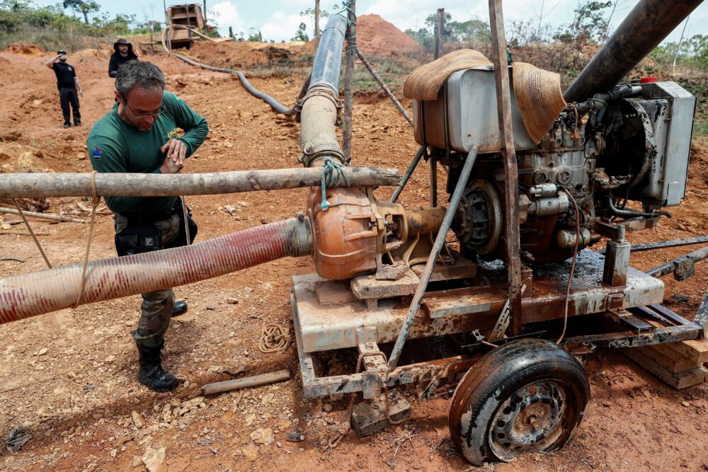 Agentes medioambientales y miembros de Policía Federal mientras confiscan maquinaría usada en la extracción ilegal de oro, en los márgenes del río Xingú, a unos 70 kilómetros de la ciudad amazónica de Altamira (Brasil). EFE/ Sebastiao Moreira
