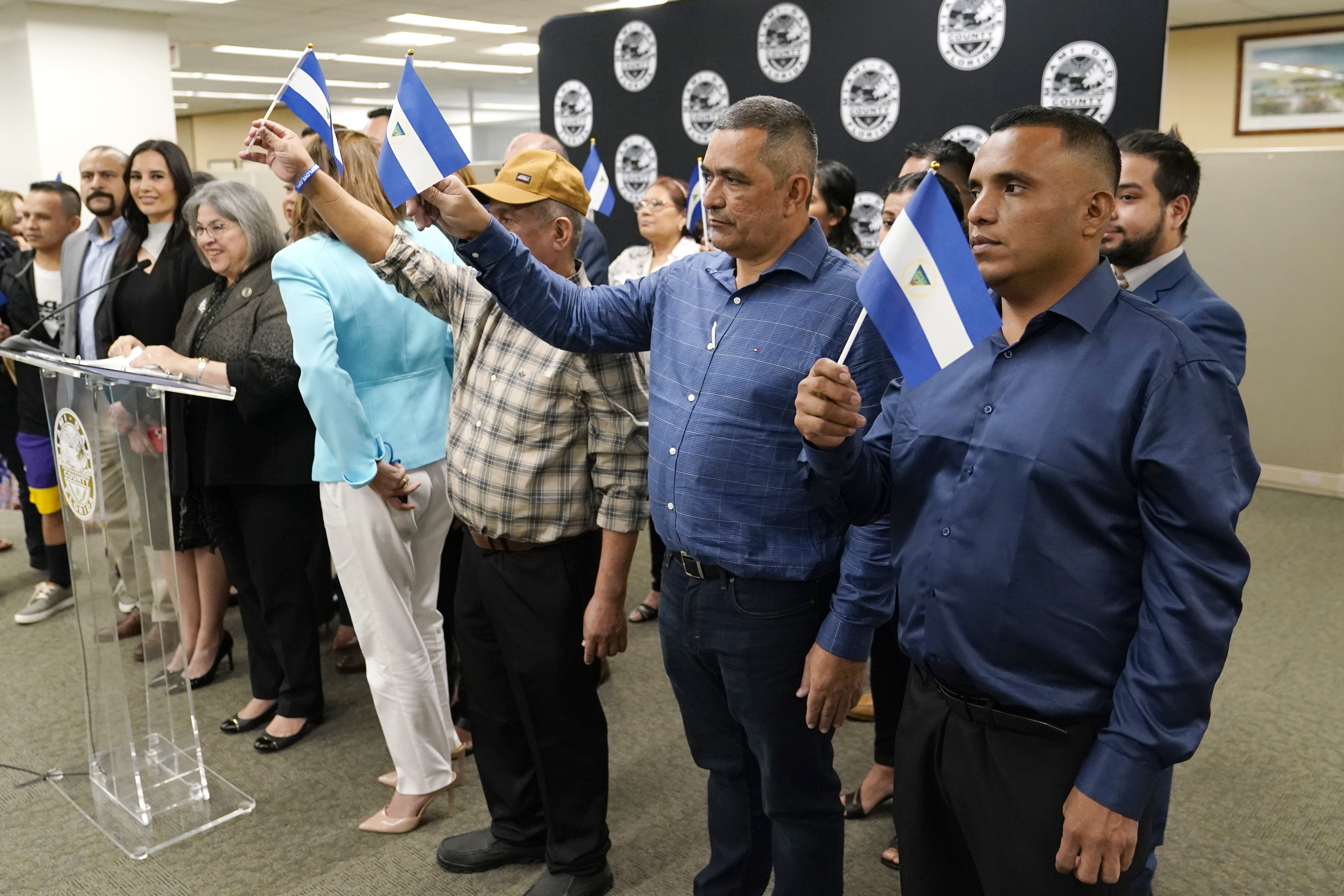 Isaías Martinez Rivas, el primer hombre vestido de azul desde la derecha, permanece parado junto a otros opositores politicos de Nicaragua recientemente liberados durante una rueda de prensa en la oficina de la alcaldesa del condado de Miami-Dade, Daniella Levine-Cava, el miércoles 15 de febrero de 2023, in Miami. (AP Foto/Lynne Sladky)