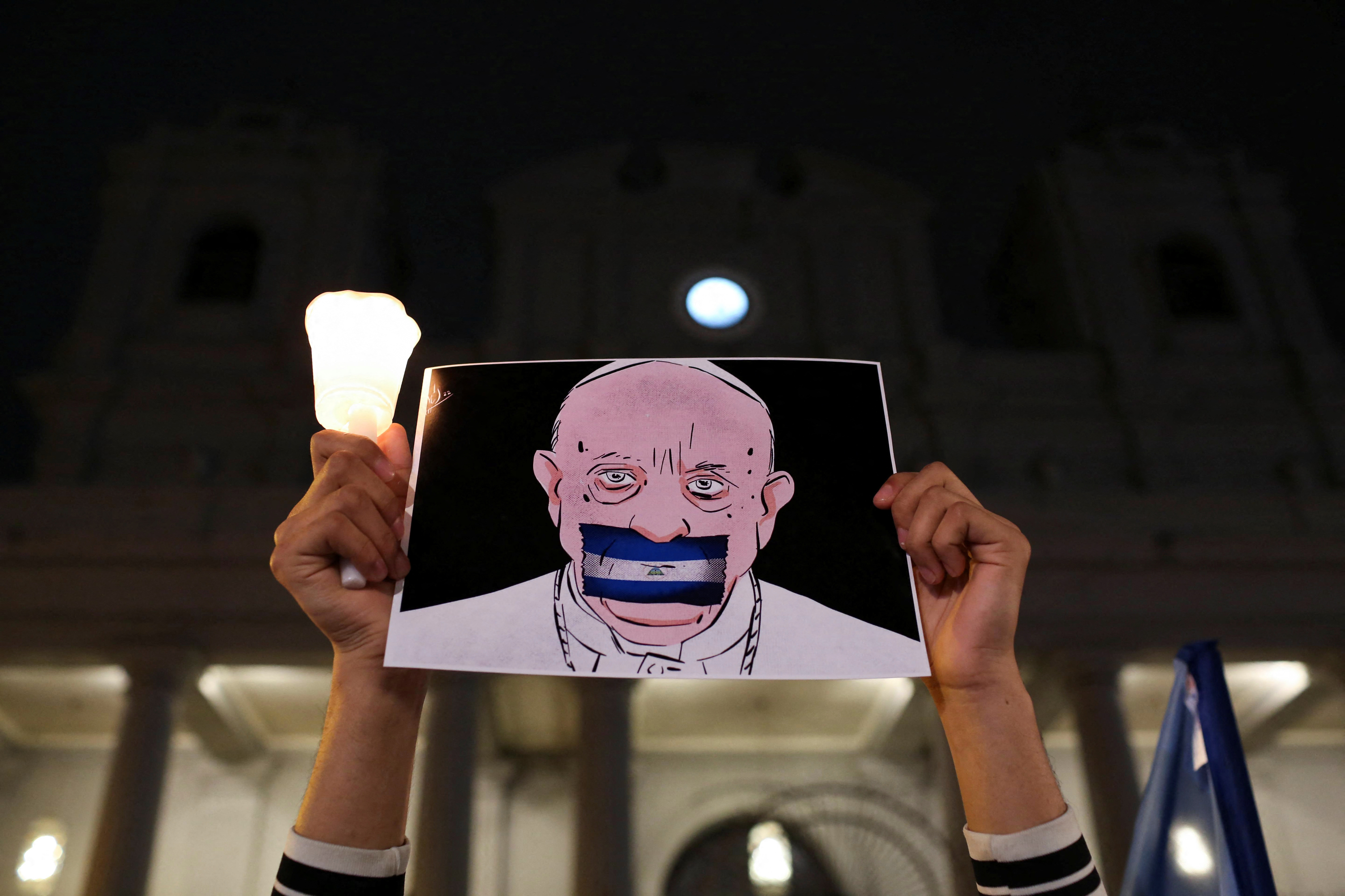 Un nicaragüense exiliado en Costa Rica sostiene un dibujo del Papa Francisco con una bandera nicaragüense tapándole la boca (REUTERS/Mayela Lopez)