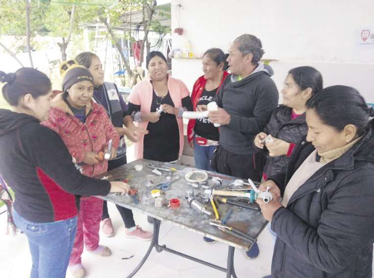 Mujeres capacitándose en plomería y electricidad 