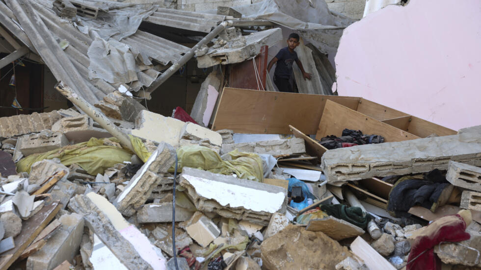 Un niño palestino recorre los restos de un edificio bombardeado por Israel en el campamento de refugiados de Rafah, en el sur de la Franja de Gaza, el 15 de octubre de 2023